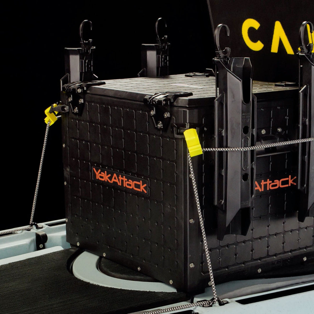 Delta Grip bungee gear hooks holding a black crate in a kayak with yellow cord locks