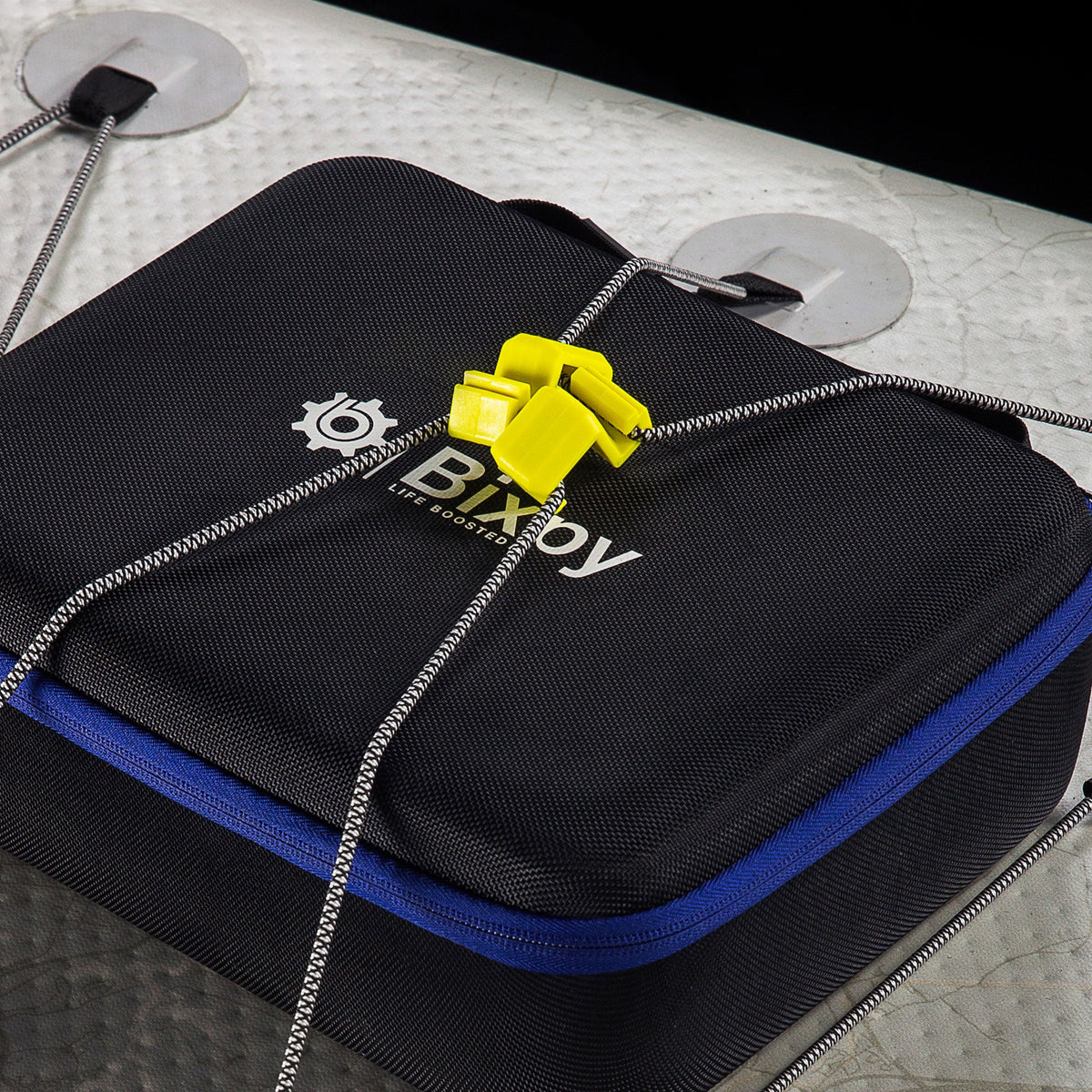 Delta Grip bungee gear hooks holding bungee over a black case on an inflatable