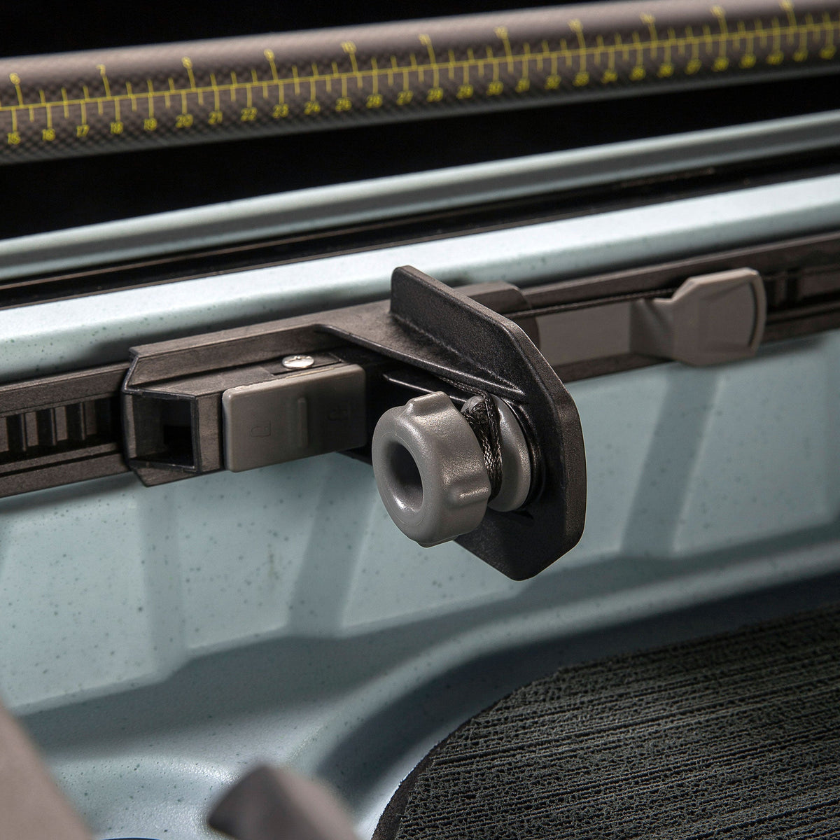Slide lock kayak foot brace with grey knob on a rail track, close-up