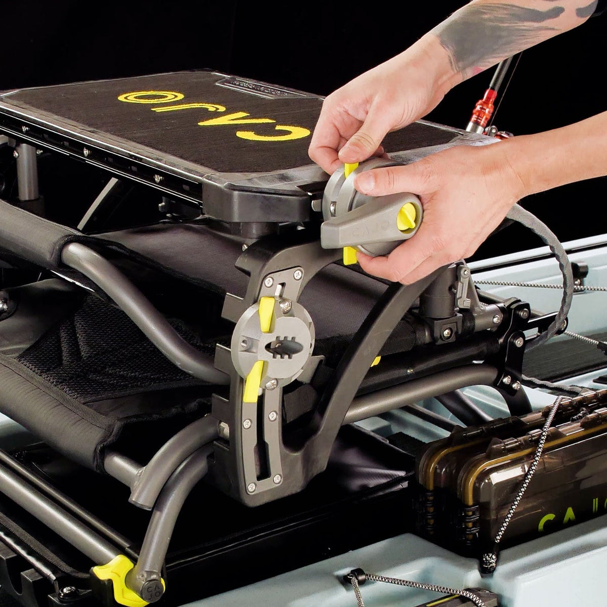 Hands fitting the Traverse rudder steering handle mount onto a kayak seat frame
